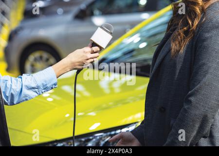 Reporter, der Medien- oder Vox-Pop-Interviews mit nicht erkennbarer weiblicher Person macht. Mikrofon mit weißem Kopierraum. Stockfoto
