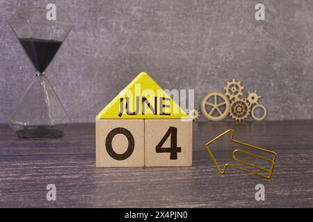 Kreidetafel mit Kalenderdatum Juni 04 auf weißem Würfel auf Holztisch Stockfoto