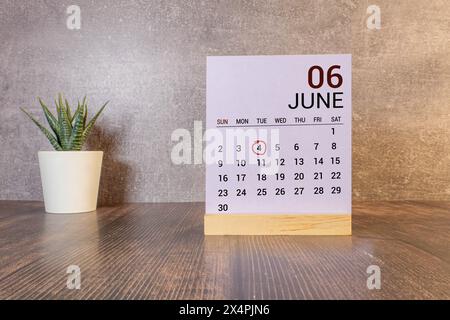 Kreidetafel mit Kalenderdatum Juni 04 auf weißem Würfel auf Holztisch Stockfoto