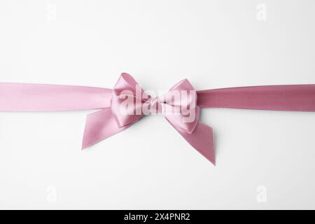 Pinkes Satinband mit Schleife auf weißem Hintergrund, Draufsicht Stockfoto
