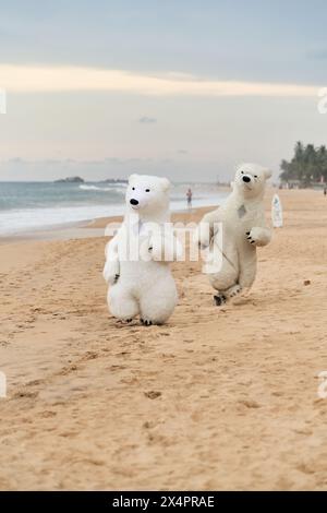 Animateure, die als Eisbären verkleidet sind, unterhalten die Leute am Strand Stockfoto
