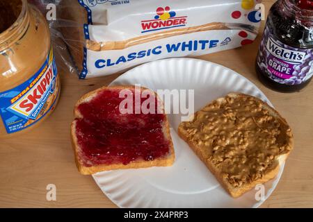 Ein Sandwich mit Erdnussbutter und Marmelade auf Wonder Bread ist ein Kultstück für die Kindheit zum Mittagessen, 2024, USA Stockfoto