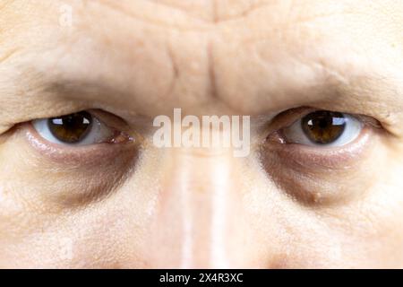 Dieses Bild fängt die intensiven und ausdrucksstarken Augen eines 45-jährigen Mannes ein. Die komplizierten Details, von den Falten, die Geschichten von vergangenen Jahren erzählen Stockfoto