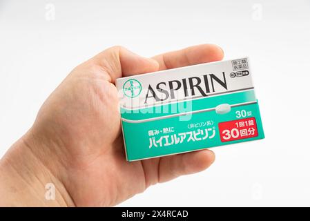 Fuji City, Präfektur Shizuoka, Japan - 23. April 2024: Hand mit Aspirin 30 Tabletten von Bayer Global isoliert auf weißem Hintergrund. Stockfoto