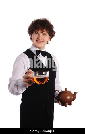 Junger, gutaussehender, lächelnder Kellner mit brauner Keramik-Teekanne und großer Tasse, isoliert auf weiß Stockfoto