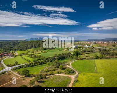 Aus der Vogelperspektive der grünen Felder im Frühling in Pla de Bages. Im Hintergrund der Berg Montserrat (Barcelona, ​​Catalonia, Spanien) Stockfoto