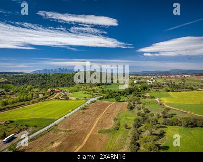 Aus der Vogelperspektive der grünen Felder im Frühling in Pla de Bages. Im Hintergrund der Berg Montserrat (Barcelona, ​​Catalonia, Spanien) Stockfoto