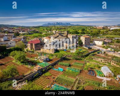 Aus der Vogelperspektive auf das historische Zentrum und die Kirche Sant Fruitós de Bages an einem Frühlingsmorgen. Im Hintergrund der Berg Montserrat (Spanien) Stockfoto