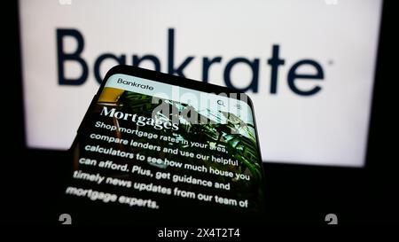 Mobiltelefon mit Website des US-amerikanischen Finanzunternehmens Bankrate LLC vor dem Geschäftslogo. Fokussieren Sie sich oben links auf der Telefonanzeige. Stockfoto