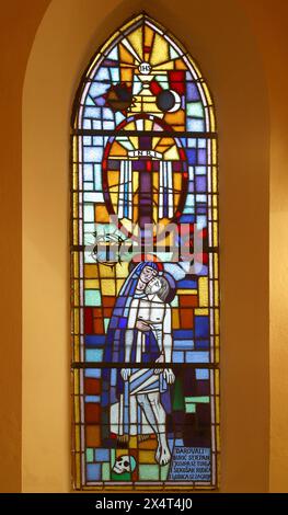 Maria mit Jesus unter dem Kreuz, Buntglasfenster in der Pfarrkirche Mariä Himmelfahrt in Tuhelj, Kroatien Stockfoto