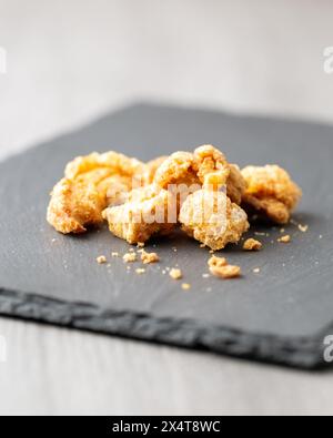 Snack mit gesalzenen Schweineschalen auf Schiefer Stockfoto