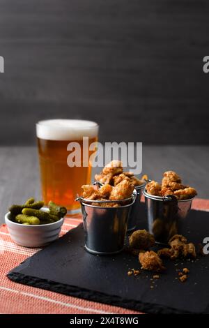 Englischer Pub-Snack mit gesalzener Schweineschale in Minieimern mit einem Glas Bier Stockfoto