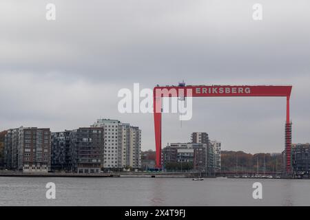 Göteborg, Schweden - Oktober 30 2021: Kran im Hafenbereich mit Gerüsten, umgeben von Wohnhäusern. Bauarbeiter sichtbar auf Gerüsten Stockfoto