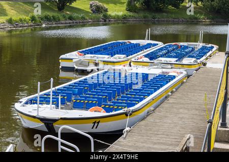 Göteborg, Schweden - 20. Juni 2021: Leere Touristenboote an einer Brücke in einem Kanal anlegen. Bäume und Park im Hintergrund. Keine sichtbaren Personen. Stockfoto