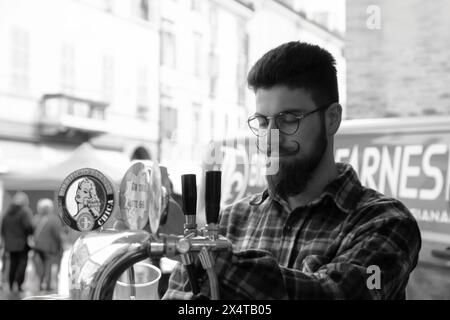 Junger Barkeeper, der Bier auf der Dorfparty gießt Stockfoto