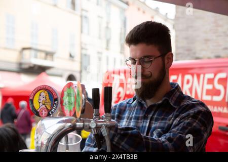 Junger Barkeeper, der Bier auf der Dorfparty gießt Stockfoto