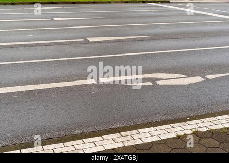 Richtungspfeile auf einer nassen Asphaltstraße Stockfoto