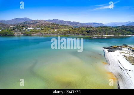 Silver Sands of Morar Highland Schottland Waldbäume im Frühling und lebhafte Farben des Sandes und des Meeres bei Flut Stockfoto