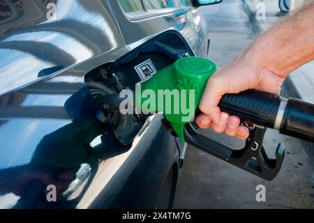 Die Hand des Mannes hält eine Gaspistole, betankt an einer Tankstelle. Ansicht schließen. Stockfoto