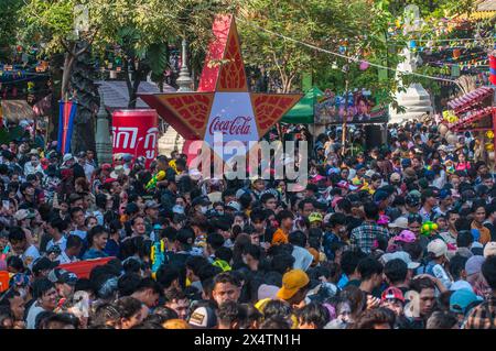 Eine dichte Menschenmenge in der Nähe einer zweisprachigen Coca-Cola-Werbung während des kambodschanischen Neujahrsfestes. Wat Phnom, Phnom Penh, Kambodscha. © Kraig Lieb Stockfoto