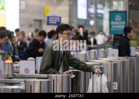 Peking, China. Mai 2024. Ein Passagier geht am 5. Mai 2024 durch eine Ticketsperre in der Ankunftshalle des Bahnhofs Shanghai Hongqiao im ostchinesischen Shanghai. China verzeichnete am letzten Tag des fünftägigen Maifeiertags eine Zunahme der Passagierreisen. Quelle: Wang Xiang/Xinhua/Alamy Live News Stockfoto