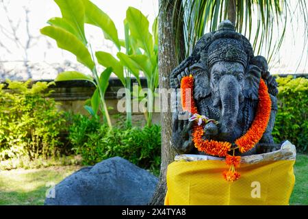 Statue von Lord Ganesha mit einer gelben Girlande, eine Tradition der religiösen Hindubali Stockfoto