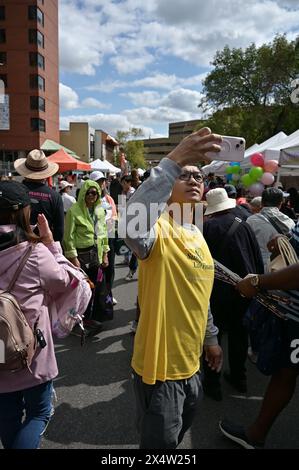 Ein junger Mann fotografiert die Menschenmassen beim chinesischen Festival in Calgary Chinatown Stockfoto