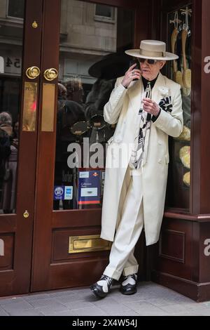 London, Großbritannien. Mai 2024. Ein eleganter Gentleman, weithin bekannt als „Soho George“, entspannt sich in einer Tür. Am jährlichen Grand Flaneur Walk nehmen eine Gruppe von elegant gekleideten Jungs, Kapellen und Tänzerinnen Teil, die neben der Statue von Beau Brummell in der Jermyn Street beginnen und dann durch die Londoner St. James' Gegend schlendern. Quelle: Imageplotter/Alamy Live News Stockfoto