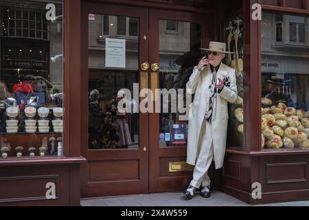 London, Großbritannien. Mai 2024. Ein eleganter Gentleman, weithin bekannt als „Soho George“, entspannt sich in einer Tür. Am jährlichen Grand Flaneur Walk nehmen eine Gruppe von elegant gekleideten Jungs, Kapellen und Tänzerinnen Teil, die neben der Statue von Beau Brummell in der Jermyn Street beginnen und dann durch die Londoner St. James' Gegend schlendern. Quelle: Imageplotter/Alamy Live News Stockfoto