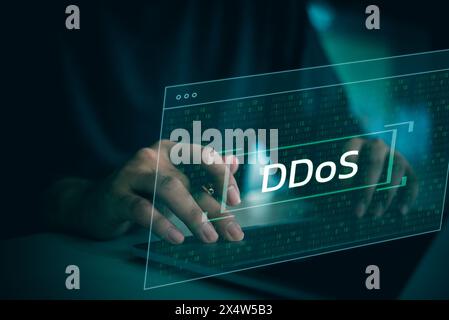 Eine Person tippt auf einem Laptop mit dem Wort DDoS auf dem Bildschirm. Konzept der Dringlichkeit und Wichtigkeit, da die Person wahrscheinlich an einer kritischen Aufgabe arbeitet Stockfoto
