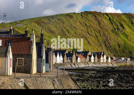 Crovie, ein winziges Fischerdorf in Aberdeenshire, schmiegt sich an einen schmalen Felsvorsprung zwischen dem Meer und den hohen Klippen und schafft so eine einzigartige malerische Szene. Stockfoto