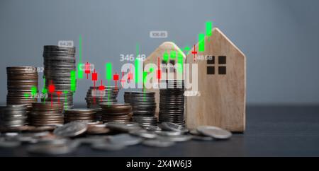 Analyse Der Immobilieninvestitionen. Münzen und Holzhäuser mit einem überlagerten Börsendiagramm, das Trends auf dem Immobilienmarkt und Finanzimmobilien darstellt Stockfoto