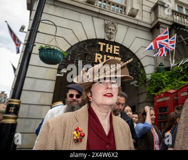 London, Großbritannien. 5. Mai 2024. Elegant gekleidete Personen passieren das Ritz Hotel während des vierten Grand flâneur Walk. Beginnend an der Beau Brummell Statue in der Jermyn Street fällt der Spaziergang mit dem 25. Jahrestag des CHAP Magazins zusammen und wird definiert als ein Spaziergang ohne Zweck, der die Kunst des flâneur feiert, ohne irgendwohin zu gehen, und ein Gegenmittel für die Anforderungen des modernen Lebens und des digitalen Smartphones. Quelle: Stephen Chung / Alamy Live News Stockfoto