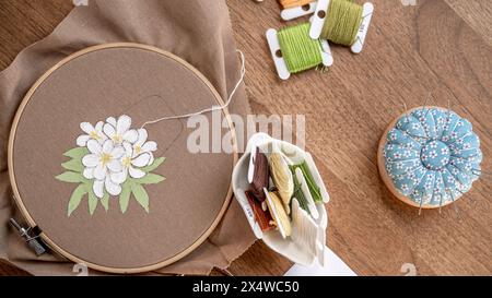 Thread & Canvas: Handgestickte Blume zum Selbermachen auf gemaltem Stoff Stockfoto