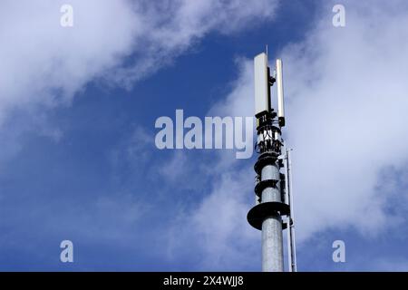 Straßenkommunikationsmast mit Telekommunikationsanlagen vor blauem Himmel, Cwmbran, Wales, Großbritannien Stockfoto