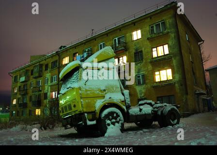 Ein alter Truck parkte nachts in der Nähe eines Betongebäudes Stockfoto