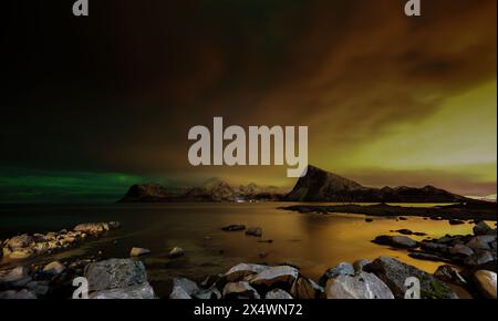 Gelbe Nordlichter über der Küstenlandschaft bei Nacht, Lofoten, Lofoten und Vesteral Inseln, Nordland, Norwegen Stockfoto