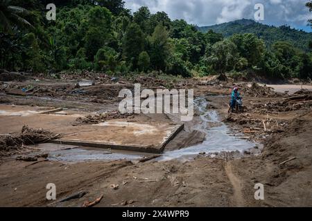 Luwu, Indonesien. Mai 2024. Ein Bewohner kommt an den Ruinen von Häusern vorbei, die durch Sturzfluten im Unterbezirk Suli, Luwu Regency, zerstört wurden. Überschwemmungen von 3 Metern Tiefe haben 13 Unterbezirke getroffen, da Wasser und Schlamm das Gebiet bedeckten und 14 Menschen töteten. Mehr als 1.000 Häuser waren betroffen und 42 wurden von den Überschwemmungen weggefegt. (Foto: Hariandi Hafid/SOPA Images/SIPA USA) Credit: SIPA USA/Alamy Live News Stockfoto