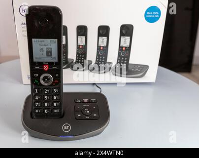 BT schnurlose analoge Telefone mit Basisstation, Anrufsperre, Anrufbeantworter, die Pappschachtel, die sie auf einem hellblauen Tisch fanden Stockfoto