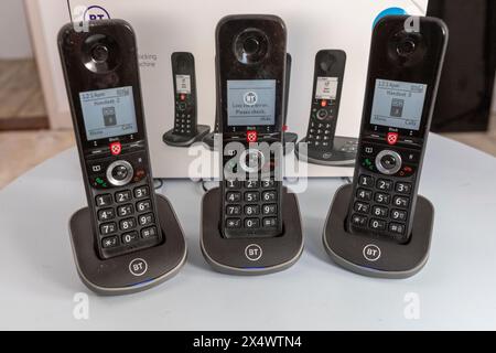 BT schnurlose analoge Telefone mit Basisstation, Anrufsperre, Anrufbeantworter, die Pappschachtel, die sie auf einem hellblauen Tisch fanden Stockfoto