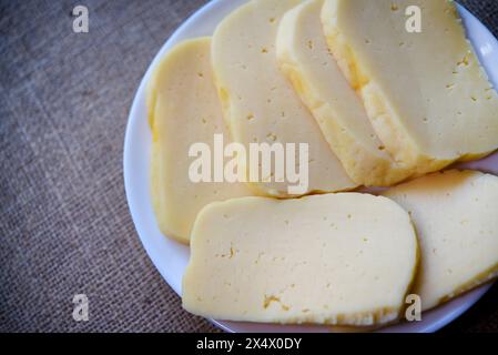 Auf einem Teller geschnittene Käsescheiben. Leckerer Käse mit Löchern. Stockfoto