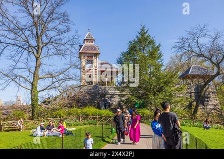 Blick auf den Central Park in Manhattan, wo die Menschen entlang der Wege in der Nähe von Belvedere Castle spazieren gehen und sich am sonnigen Frühlingstag auf grünem Gras entspannen. New York. US Stockfoto