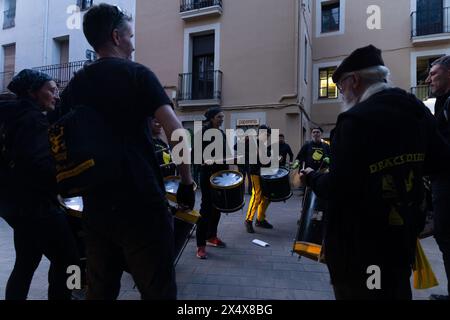 Gruppen von Personen mit Trommeln marschieren entlang der Correfocs-Parade (lit. Fire Runner). Stockfoto