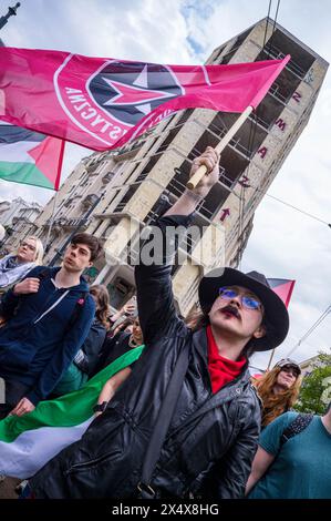 14. April 2024, Warschau, Mazowieckie, Polen: Ein Demonstrant hebt während der Kundgebung die Flagge einer sozialistischen Organisation zur Unterstützung Palästinas. Als April begann, wurde die Zahl der Todesopfer von 32.000 in Gaza überschritten, von denen 13.000 Kinder waren. Pro-palästinensische Anhänger in Warschau versammelten sich, um Solidarität mit dem Volk von Gaza zu zeigen und gegen den anhaltenden Völkermord Israels zu protestieren. Die Demonstranten versammelten sich am Plac Zbawiciela und gingen zur israelischen Botschaft. 50m von der Botschaft entfernt hindert die Polizei die Demonstranten daran, weiter zu gehen, was zu Spannungen führt. Durch Verhandlungen war der marsch Stockfoto