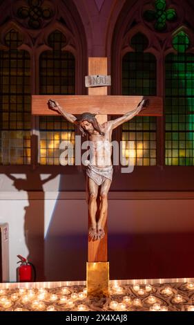 Eine gekreuzigte Figur Jesu in der Kirche und sein Schatten spiegelte sich an der Wand Stockfoto
