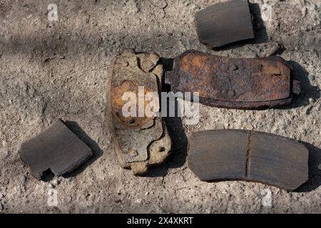 Nahaufnahme von ungleichmäßigem Bremsbelagverschleiß. Alte, rostige Teile der Bremsanlage Stockfoto