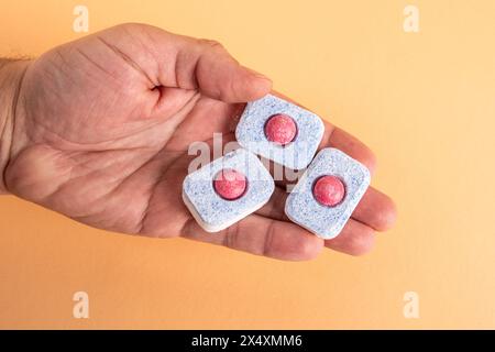 Geschirrspülkapsel in der Hand auf hellem Hintergrund. Stockfoto