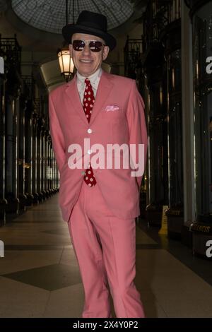 London, Großbritannien. Mai 2024. Ein Gentleman mit rosa Anzug posiert in einer dunklen Ladenfront. Damen und Herren in ihren besten Outfits treffen sich an der Beau Brummell Statue in der Jermyn Street London zum Vierten Grand Flaneur Walk. (Foto: James Willoughby/SOPA Images/SIPA USA) Credit: SIPA USA/Alamy Live News Stockfoto