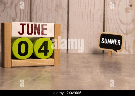 Kreidetafel mit Kalenderdatum Juni 04 auf weißem Würfel auf Holztisch Stockfoto