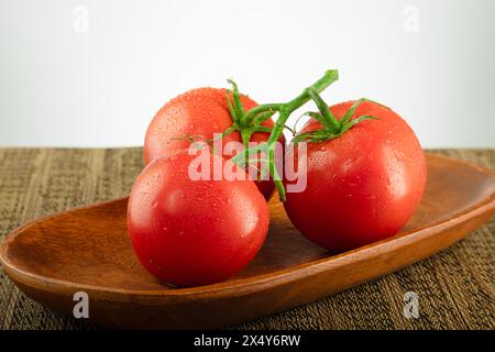 Drei rote Tomaten auf einer Weinrebe Stockfoto